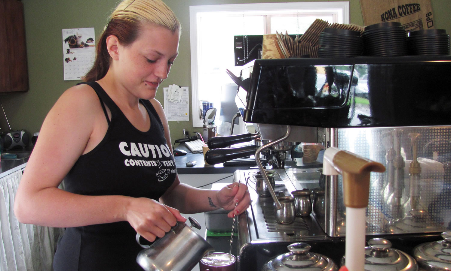Paige McKnight, a barista at Michele's Coffee Corner, in Washougal, makes a white chocolate caramel mocha Monday. The &quot;E&quot; Street business, owned by McKnight's mother Michele, has experienced a decline in business due to the economy as well as recent roadwork.