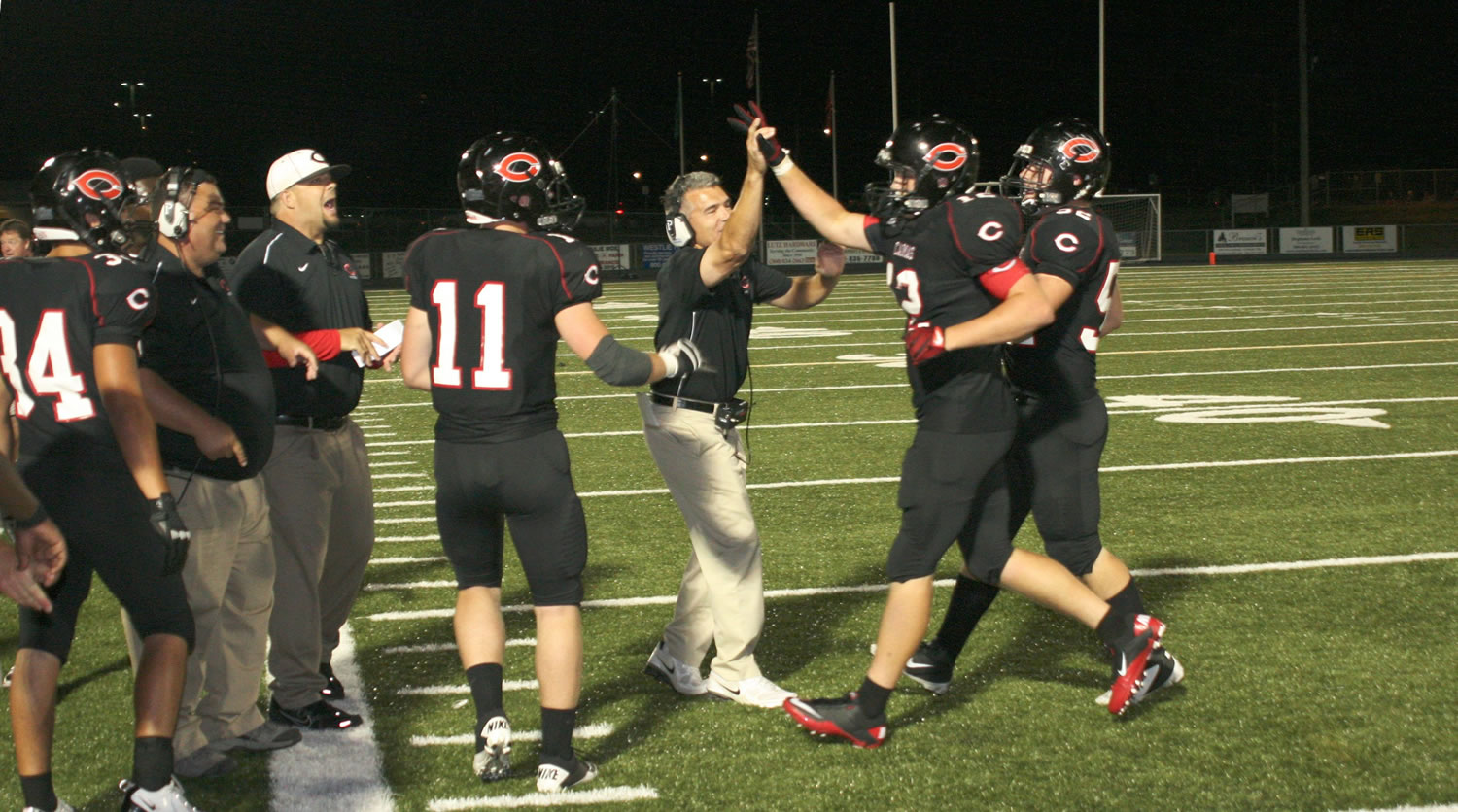 Camas High School football coaches and players congratulate John Norcross after his second touchdown Friday, at Doc Harris Stadium.
