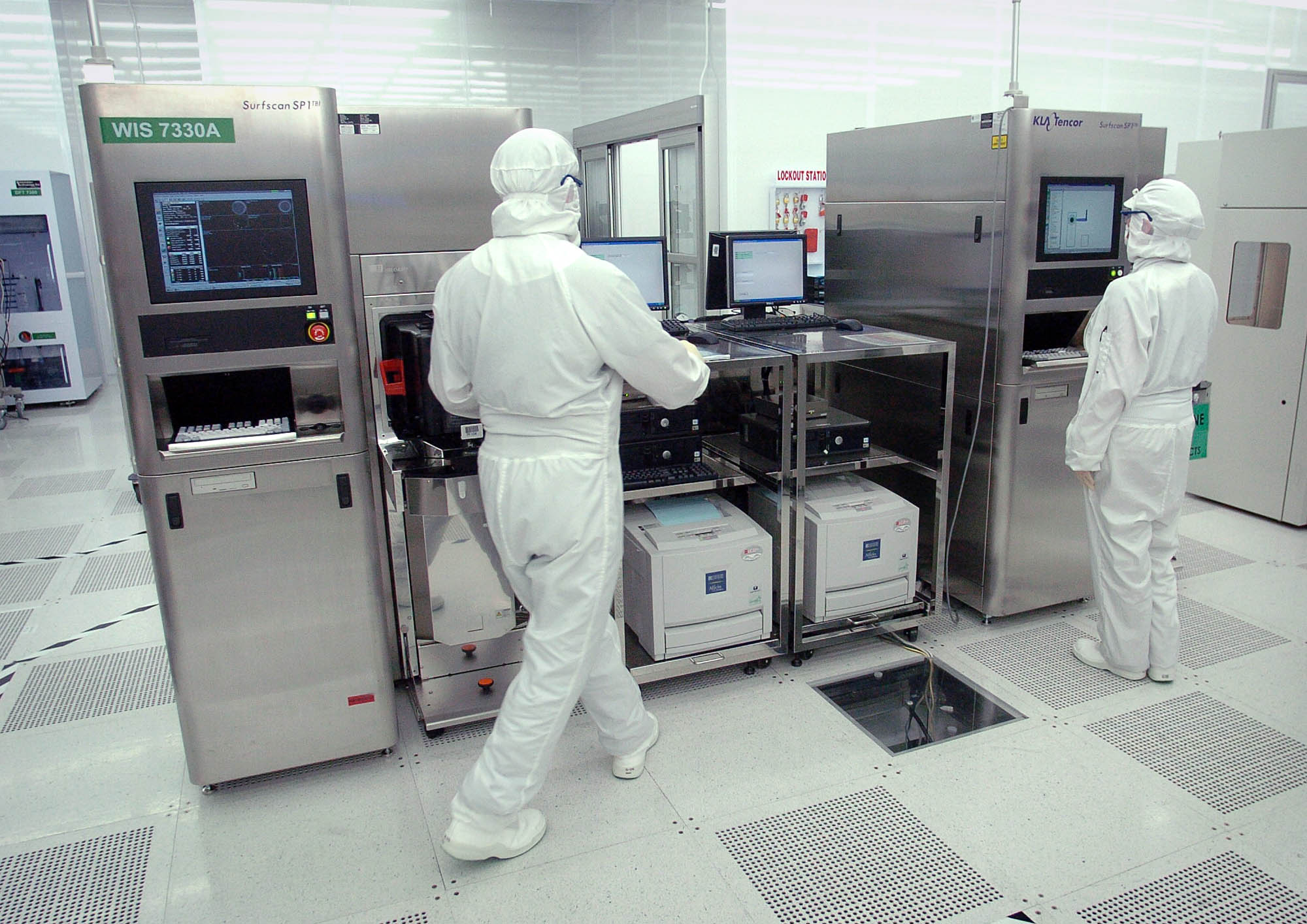 SEH America employees work on a silicon wafer manufacturing machine in the company's Vancouver plant.
