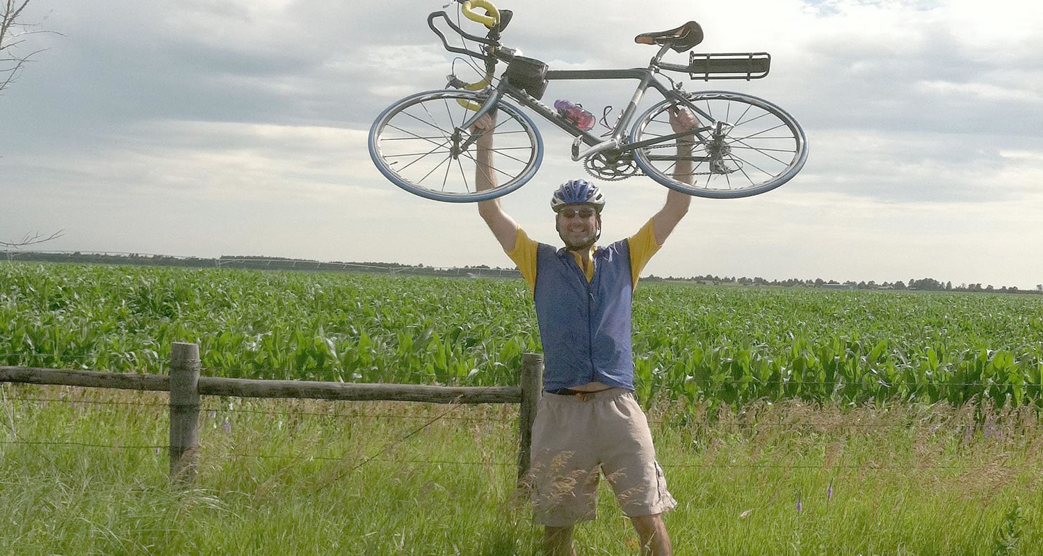 Blair raises his bike in victory after a long , hot day on a bumpy road in central Nebraska.