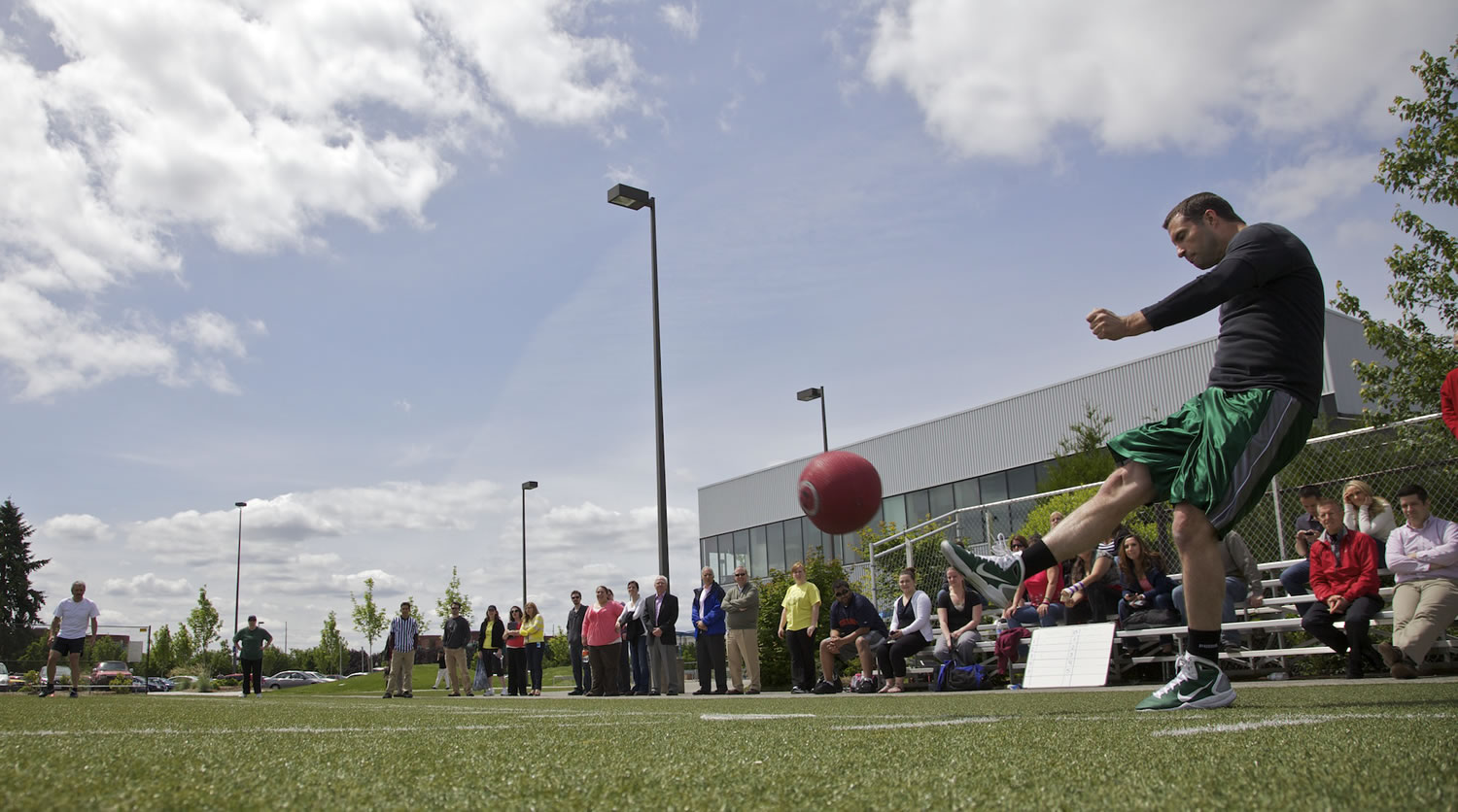 Dennison Harris kicks a ball during an employee kickball game last week at Nautilus in Vancouver.