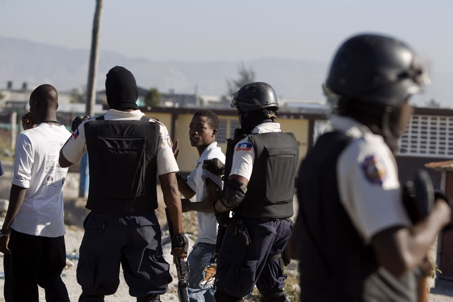 Police officers detain two demonstrators during a Christmas Eve protest at the Cite Soleil slum in Port-au-Prince, Haiti.