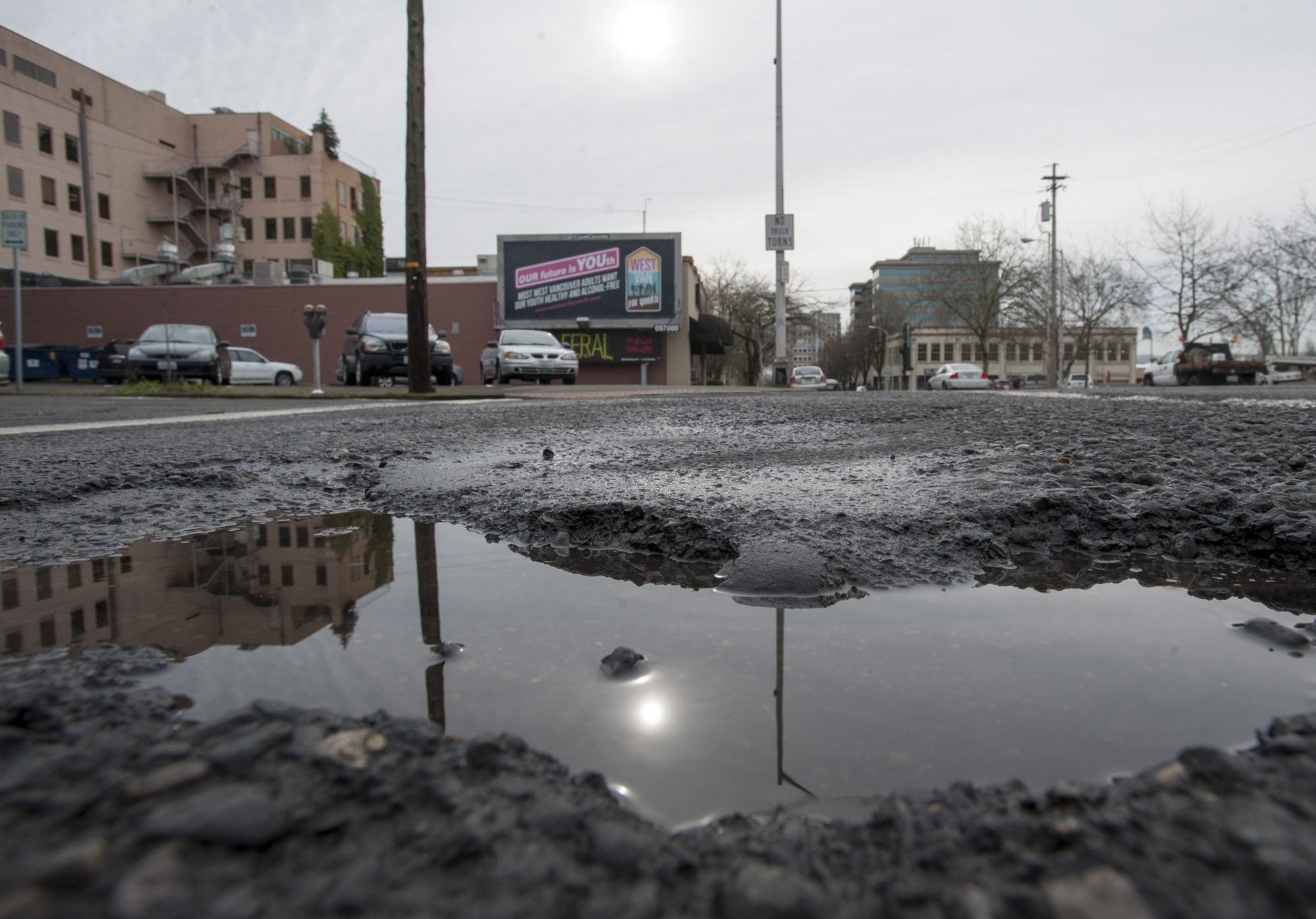 Potholes, such as this one at the intersection of West 12th and Washington streets in downtown Vancouver, are appearing countywide amid winter weather.