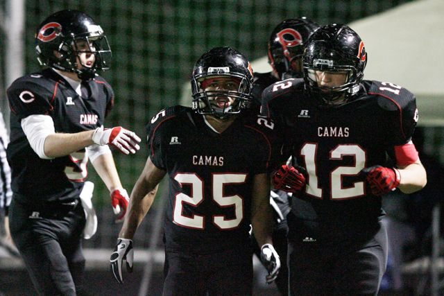 Camas players Zach Marshall (25) Jack Beall (left) and John Norcross (12) celebrate touchdown against Kennedy Catholic during 3A state tournament football game at Doc Harris Stadium.
