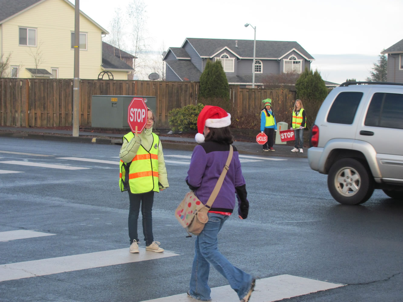 Fifth-grader Laura Teames (left) helps a student cross the busy intersection at Northwest 28th Avenue and Sierra Drive near Dorothy Fox Elementary School in Camas.