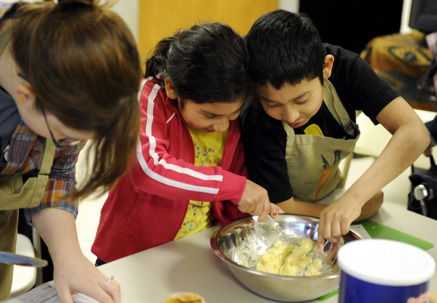 Seudy Bolon and her brother Alexander Bolon Manrero, right, mix dough for oatmeal cookies during a nutrition education class offered by a Vancouver food pantry.