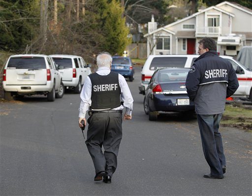 Pierce County Sheriff Paul Pastor left and detective Ed Troyer walk toward the smoldering remains of a house near Fredrickson, Wash., Sunday, Feb. 5, 2012, where, according to a sheriff's spokesman, three bodies were were found. The bodies are believed to be Josh Powell and his two sons. The explosion occurred moments after a Child Protective Services worker brought the two boys to the home for a supervised visit.