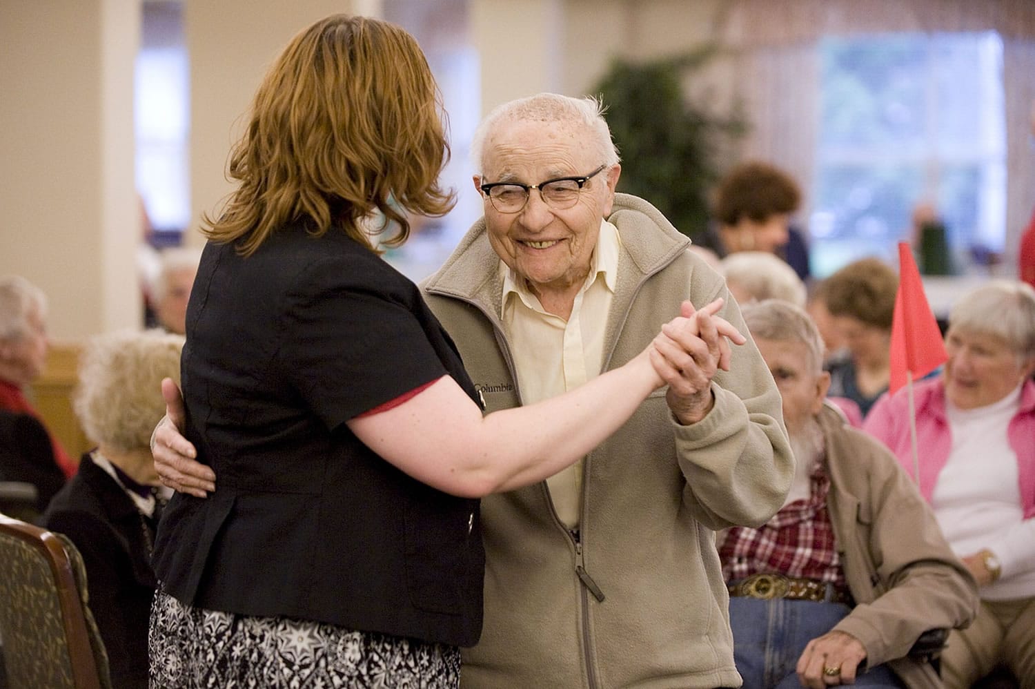 Resident Rocky Cortese, 94, dances with activities director Michelle Avdienko during a wine and cheese social hour at Vancouver's Glenwood Place Senior Living. Research suggests older people are happier than younger ones.