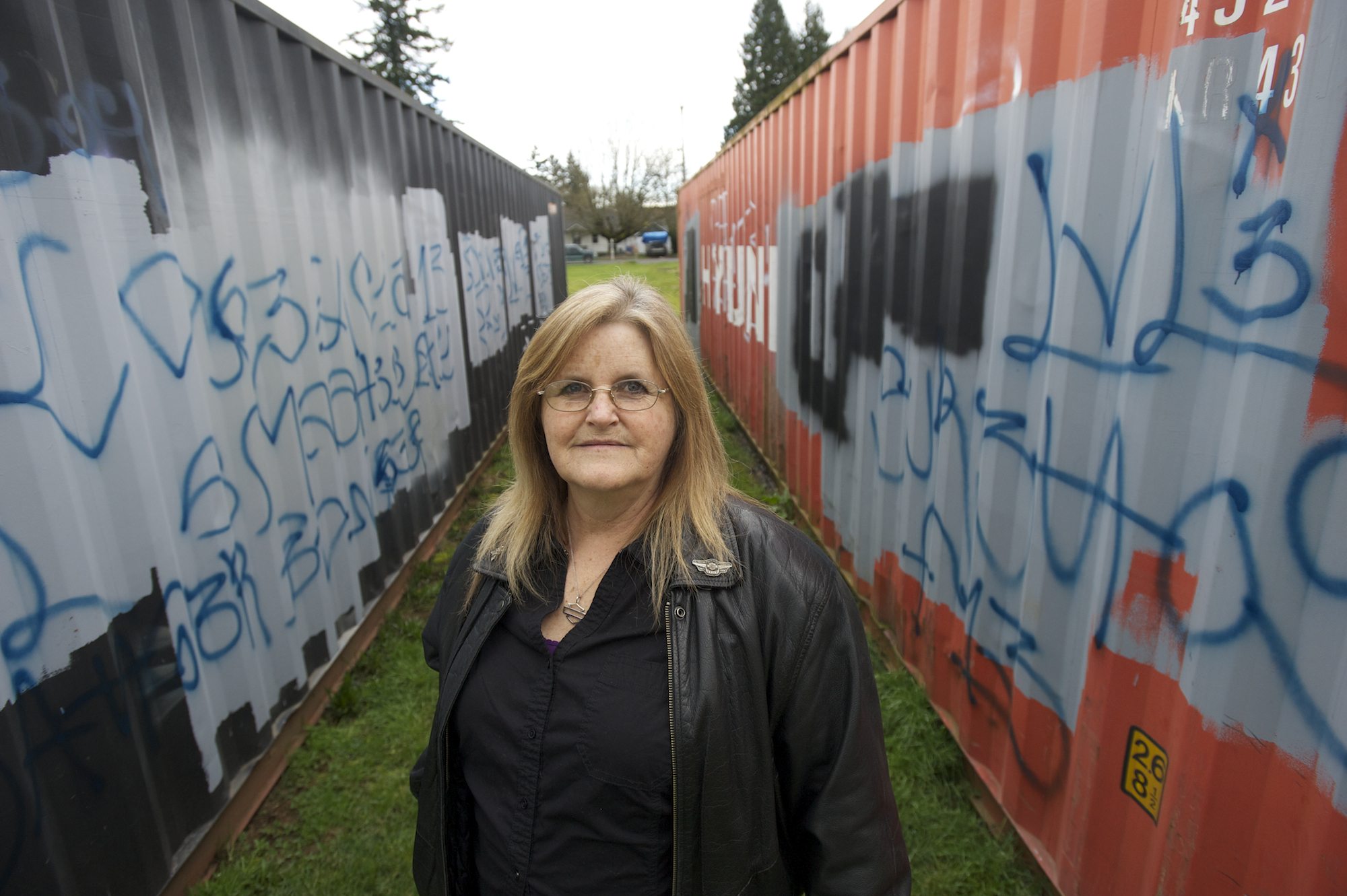 Cynthia Powers stands amid graffiti-covered shipping containers Thursday afternoon at Warrior Field in Vancouver.