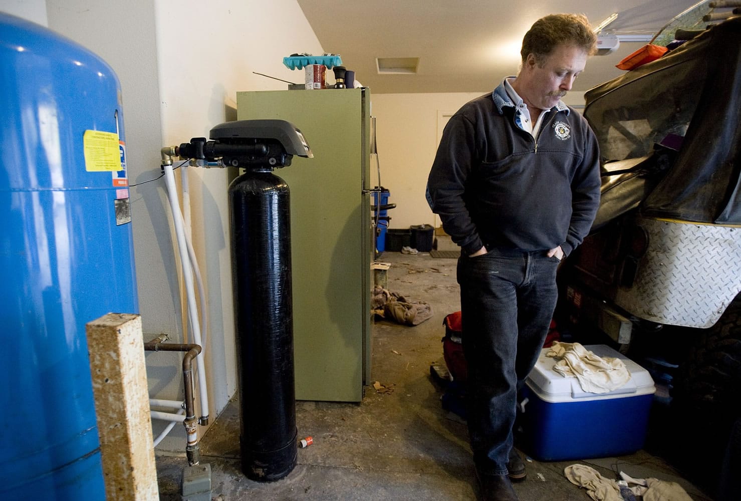 The filtration system that removes arsenic from the well water at Gordon Brooks' Amboy-area home is contained inside a black cylinder in his garage.
