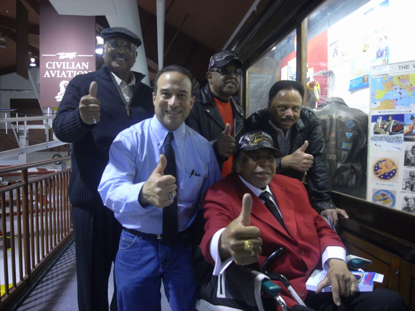 Hudsonis Bay: Ben &quot;Flaps&quot; Berry, Tuskegee Airman and Congressional Gold Medal recipient (red jacket) gives a thumbs up to Pearson Air Museum's new Tuskegee Airmen display case.