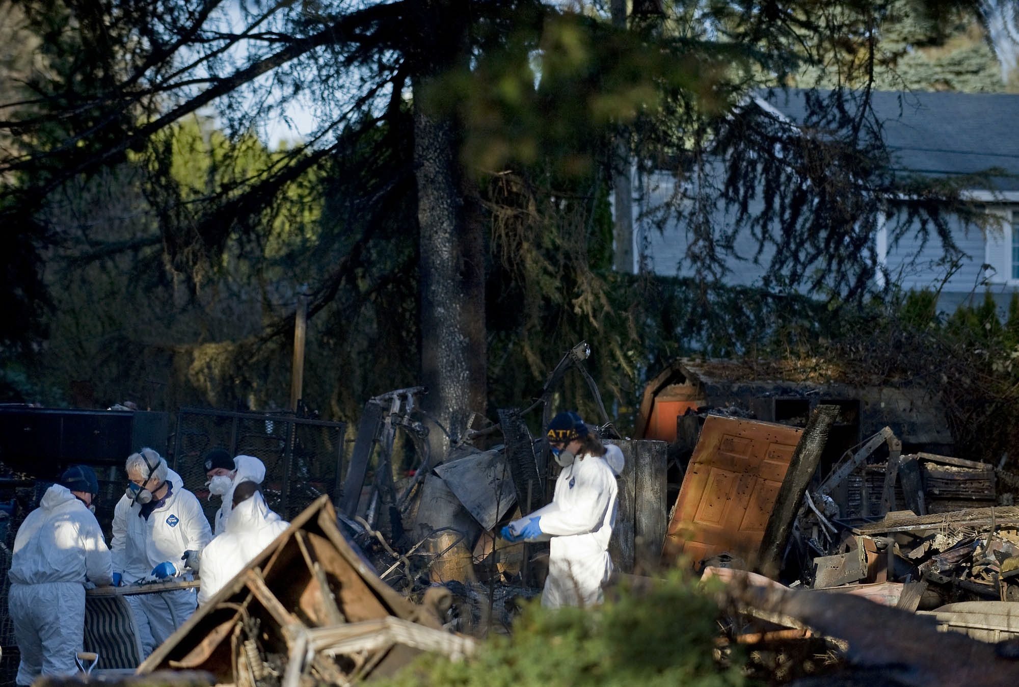 Investigators work the scene where a day earlier a man with a gun held police and firefighters off while a house burned to the ground in Washougal on Thursday December 8, 2011.
