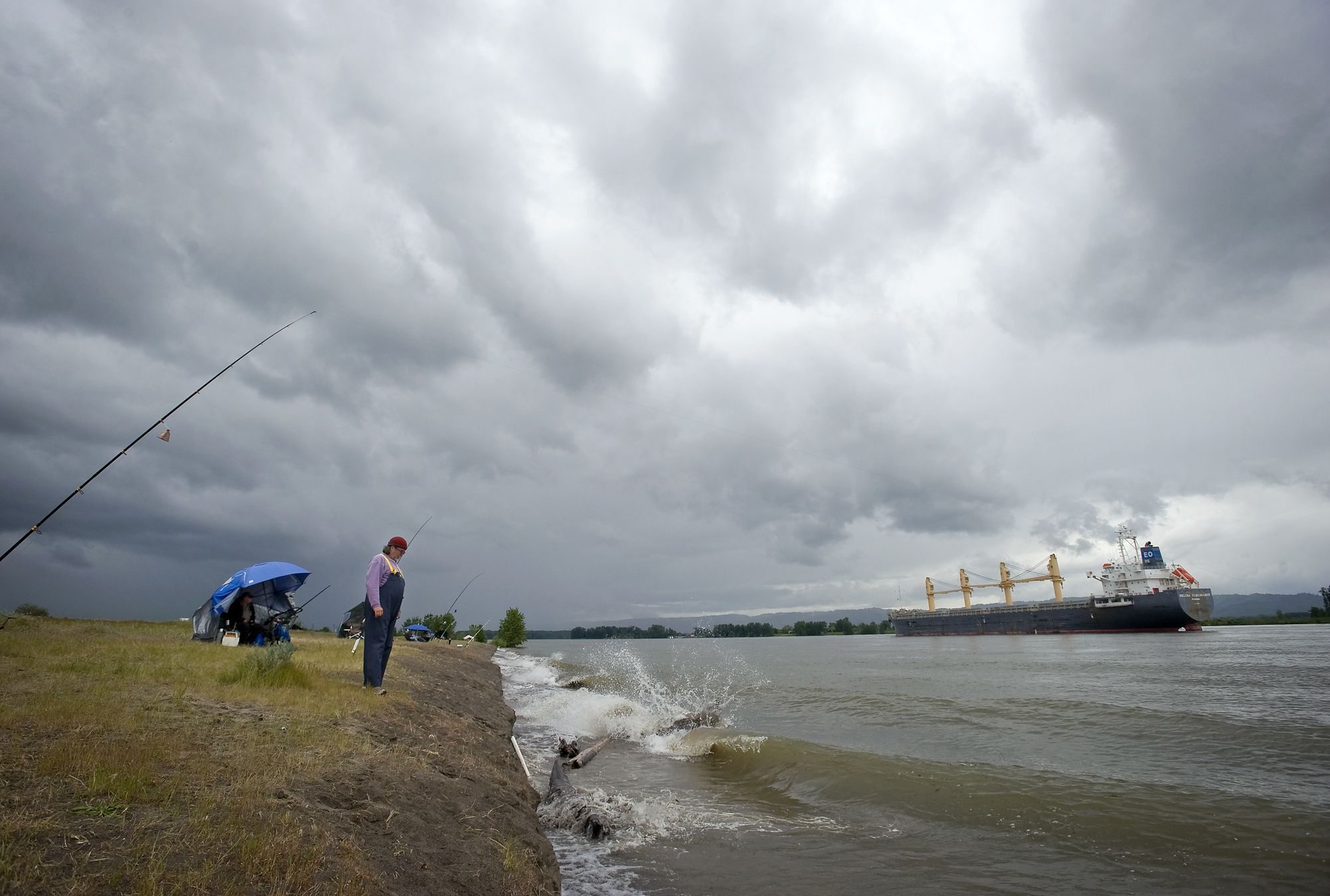 Chuck Needham watches the shoreline Wednesday as a wake rolls in from a container ship on the Columbia River at Frenchmanis Bar Park.