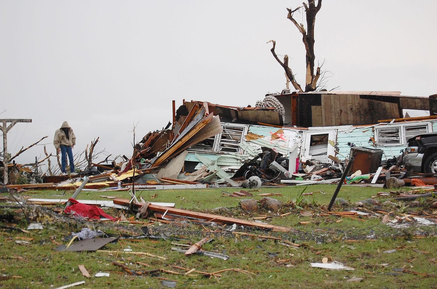 A man looks for something salvageable in the debris scattered around his demolished home in Joplin, Mo.