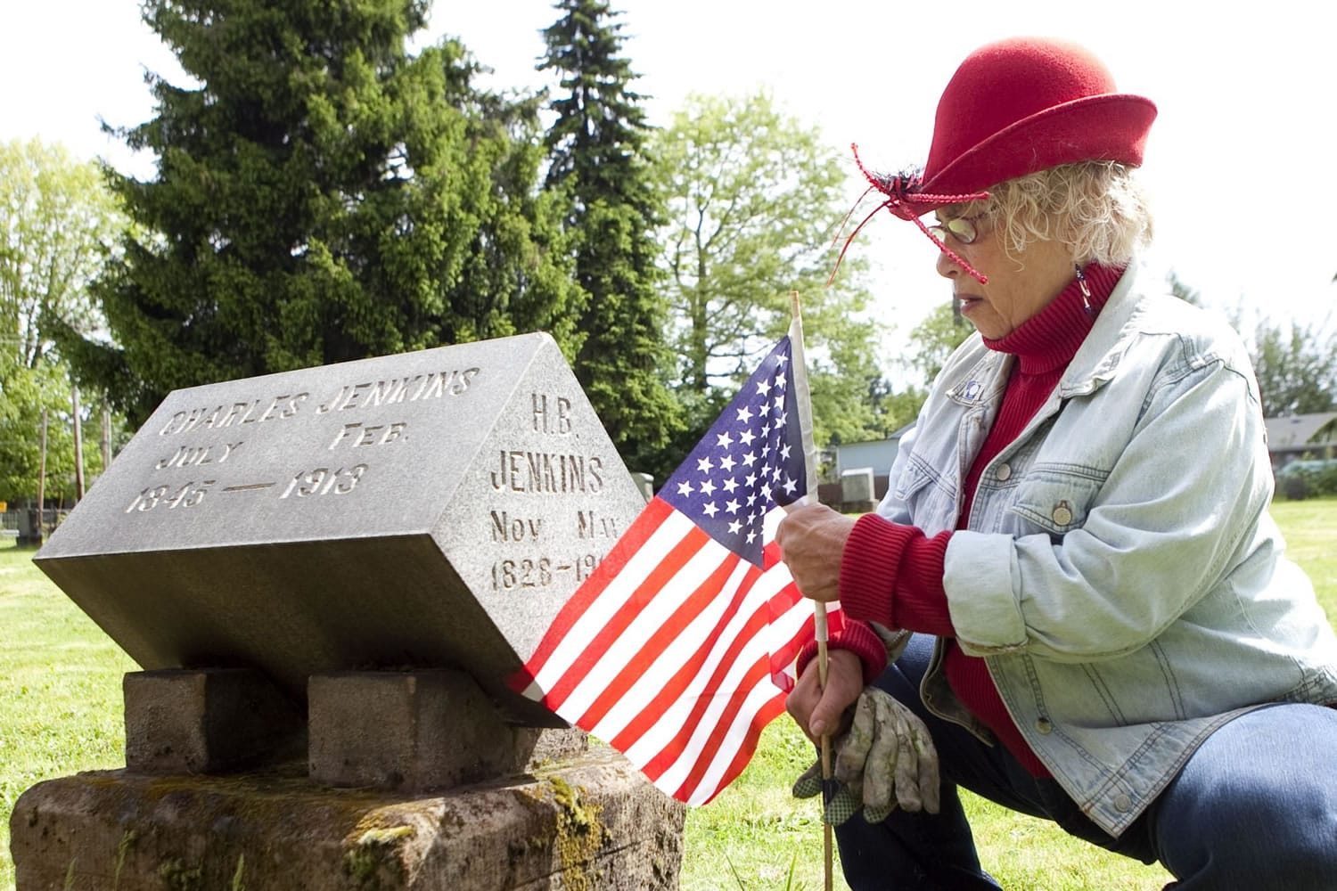 Cecelia Colson, a member of Vancouver Heritage Ambassadors,  places a flag on a veteran's grave.