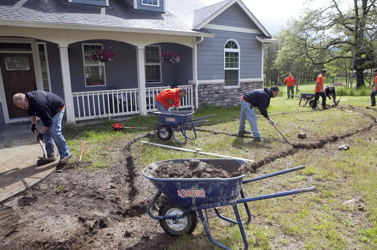 Drainage technicians with Drainage Masters LLC prepare to install a drainage system at a Battle Ground home.
