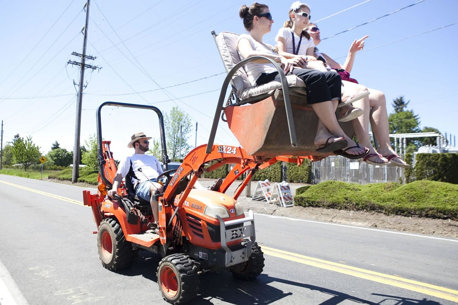 Rob Anderson sits back in his tractor seat after hoisting his wife, Cori (far right), his daughter Trista (middle) and their friend Carmen Geotschuis into the air to get a good view of the Hockinson Fun Days parade Saturday afternoon.