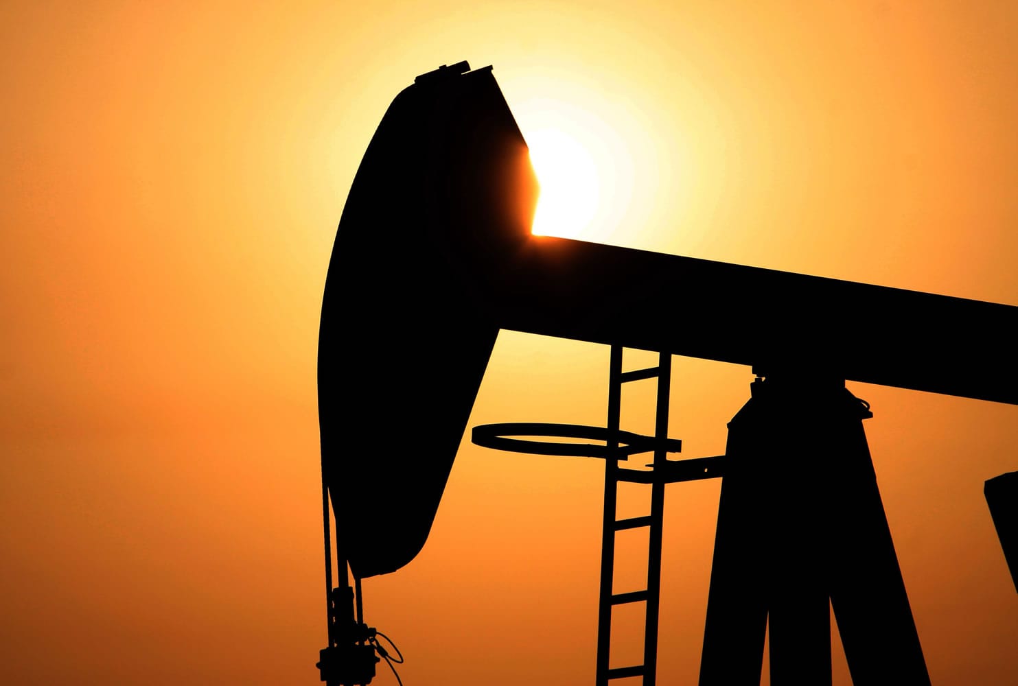 An oil pump works at sunset Wednesday in the desert oil fields of Sakhir, Bahrain.