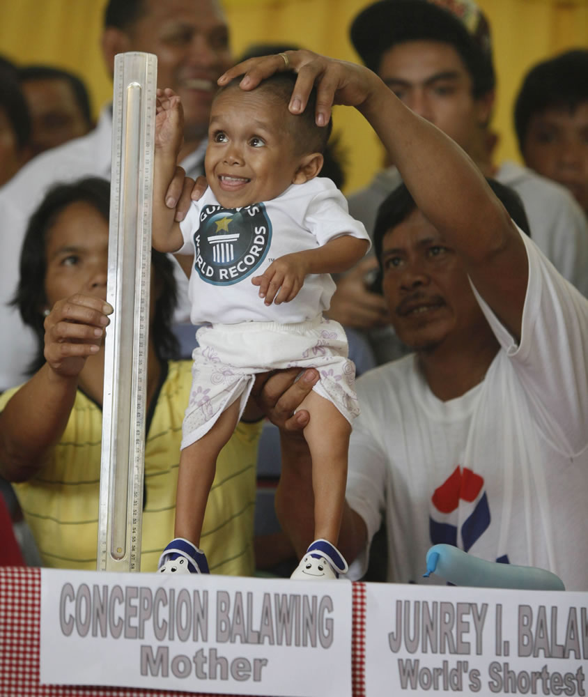 Junrey Balawing, 18, smiles as he stands next to a ruler being held by his mother Concepcion prior to the last of a series of measurements conducted Sunday by Guinness World Records at Sindangan Municipal Hall in Sindangan township, Zamboanga Del Norte province in Southern Philippines. Balawing was officially declared 'the world's shortest living man' with a measurement of 23.5 inches, dislodging Nepal's Khagendra Thapa Magar with a measurement of 26.4 inches.