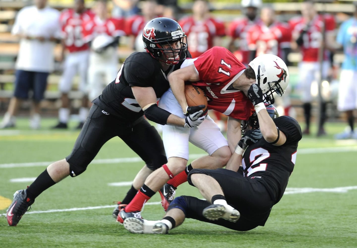 Vipers players Igor Ivanov, left, and Michael Ivanov pull down a Southern Oregon Renegades player during a football game at Kiggins Bowl on Saturday.