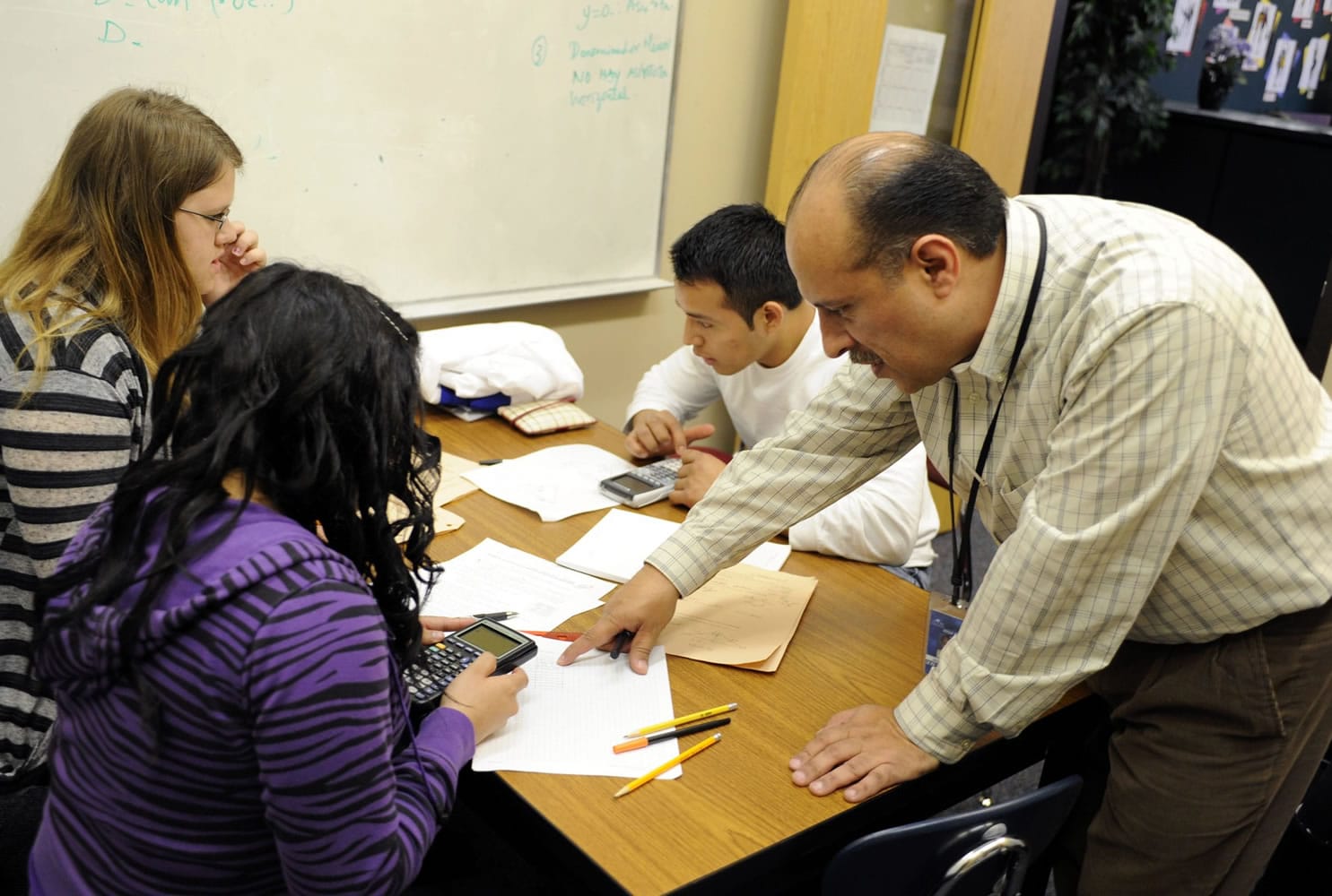 Jesus Angarita, right, works with Wilmer Lorenzo, center, Naomi Bircea, far left, and Nelly Medina in his office at Mountain View High School.