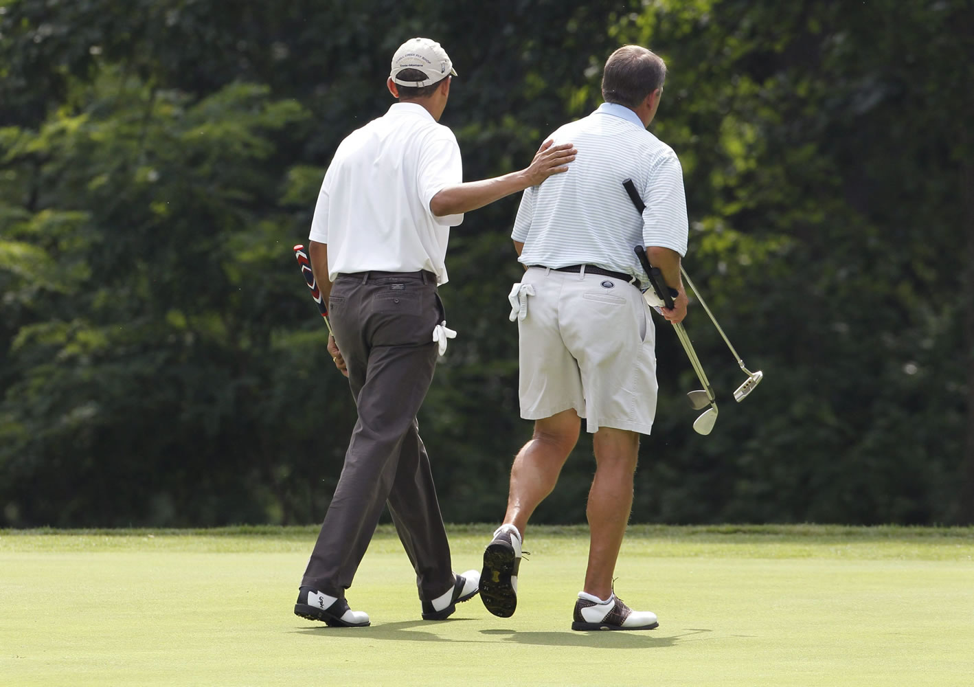 President Barack Obama walks off the first green with House Speaker John Boehner, R-Ohio, right, while golfing at Andrews Air Force Base, Md., Saturday