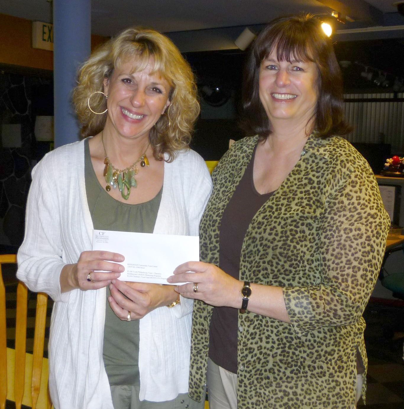 Nancy Miller, left, executive director of the Rocksolid Teen Center, accepts grant money from Anne Digenis, grants officer at The Community Foundation.