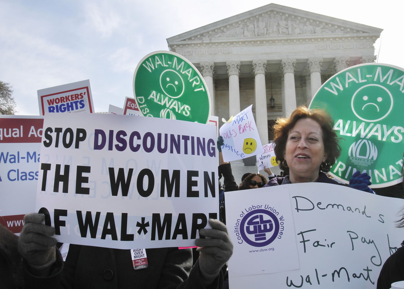 Carol Rosenblatt of Washington, right, and others take part in a rally outside the Supreme Court in Washington, D.C., in March in support of the plaintiffs in a case of women employees against Wal-Mart.