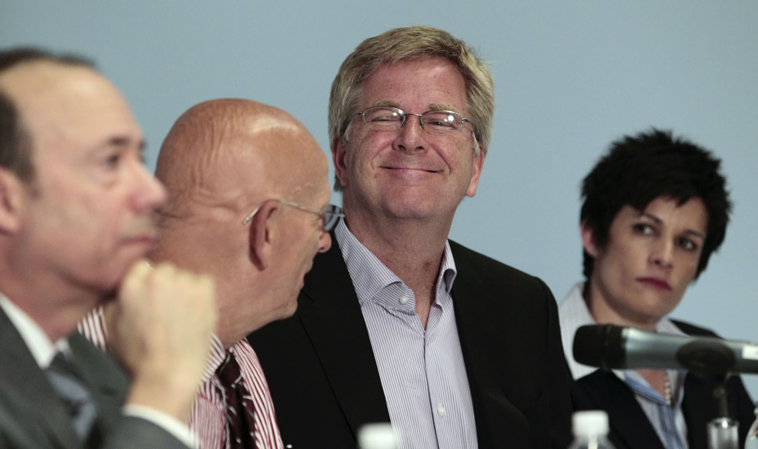 Travel guide Rick Steves, second from right, smiles as he sits with Mark Johnson, from left, Dr.