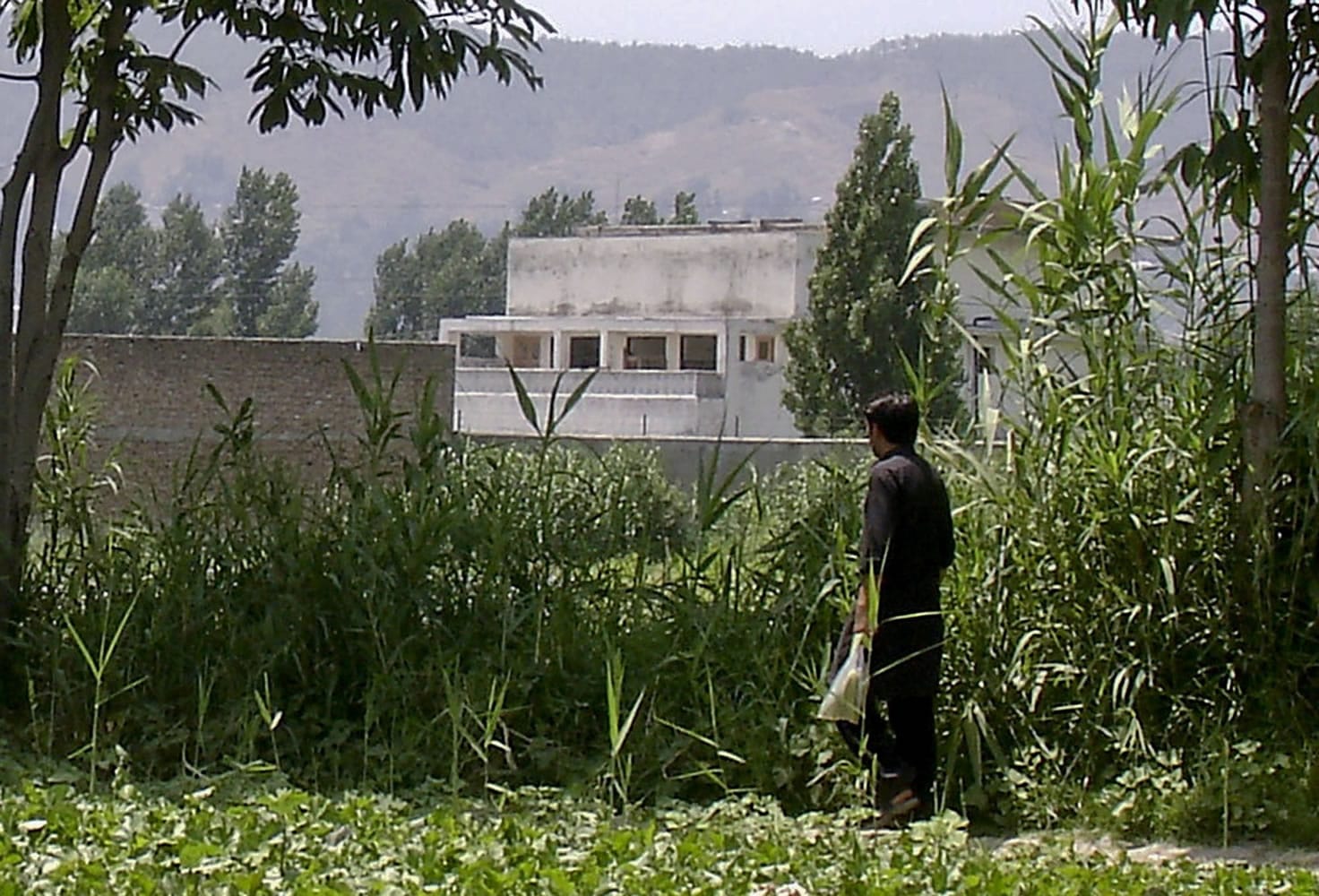 A local resident walks this month past the house  where al-Qaida leader Osama bin Laden was caught and killed in Abbottabad, Pakistan on May 2.