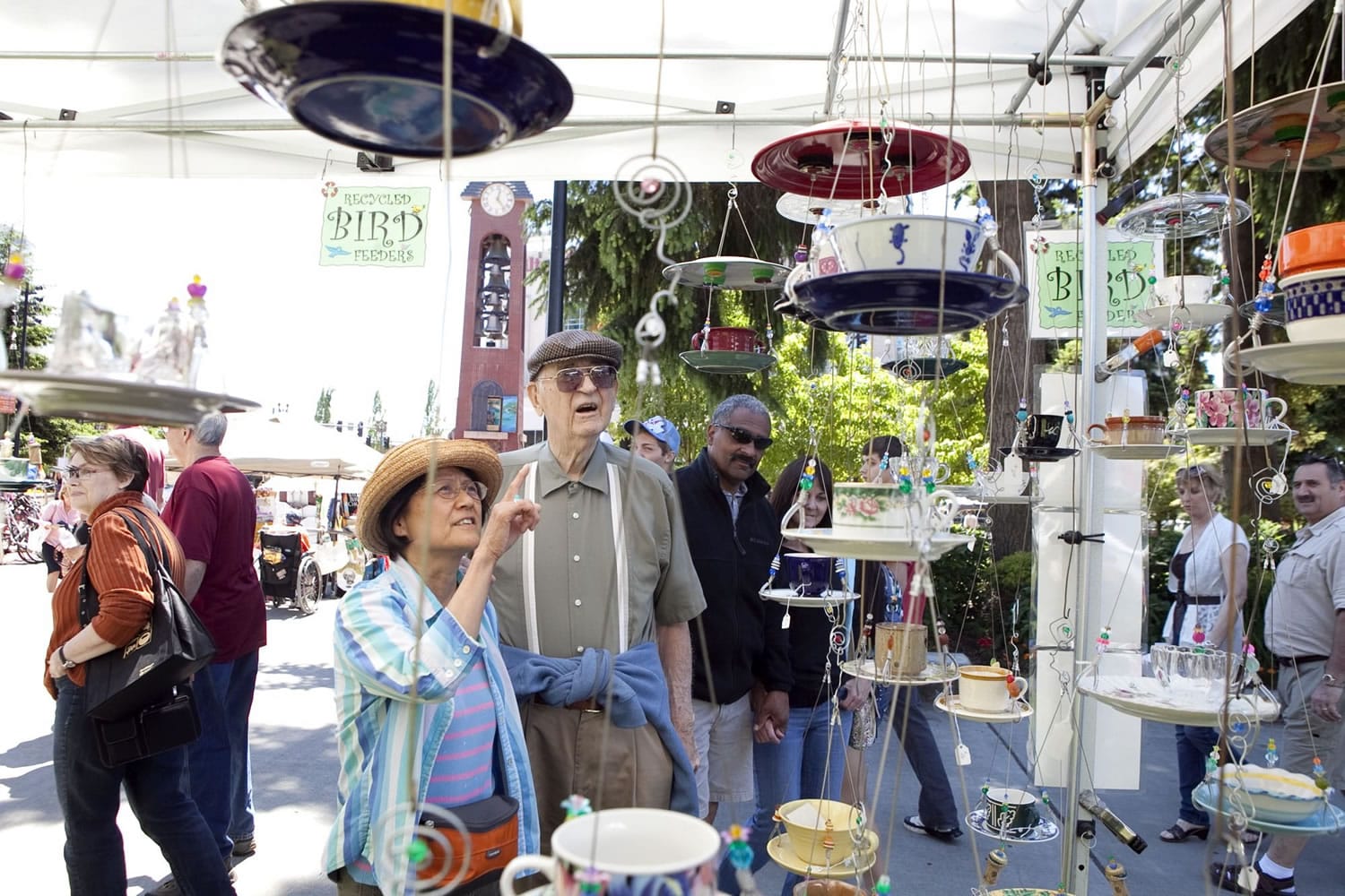 Mikiko Flynn and her husband, Tom Flynn, look at bird feeders made from cups and saucers Saturday at the sixth annual Recycled Arts Festival in Esther Short Park. The festival continues from 10 a.m. to 4 p.m.