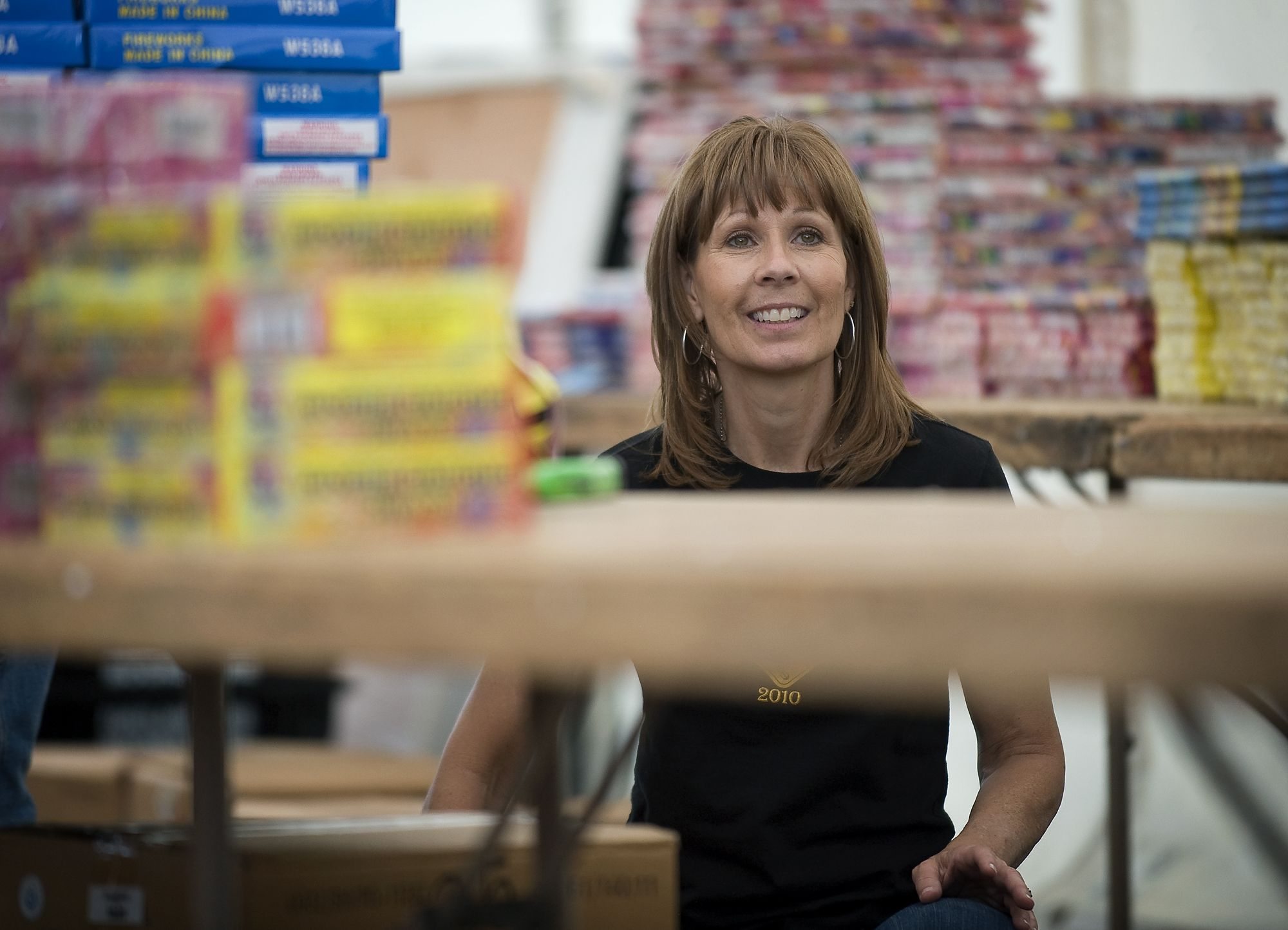 Colleen Czaplicki, of Cave Creek, Ariz., whose son Sgt. John Kyle Daggett was killed in 2008, stocks the shelves Monday at a fundraising fireworks stand at 2711 N.E.