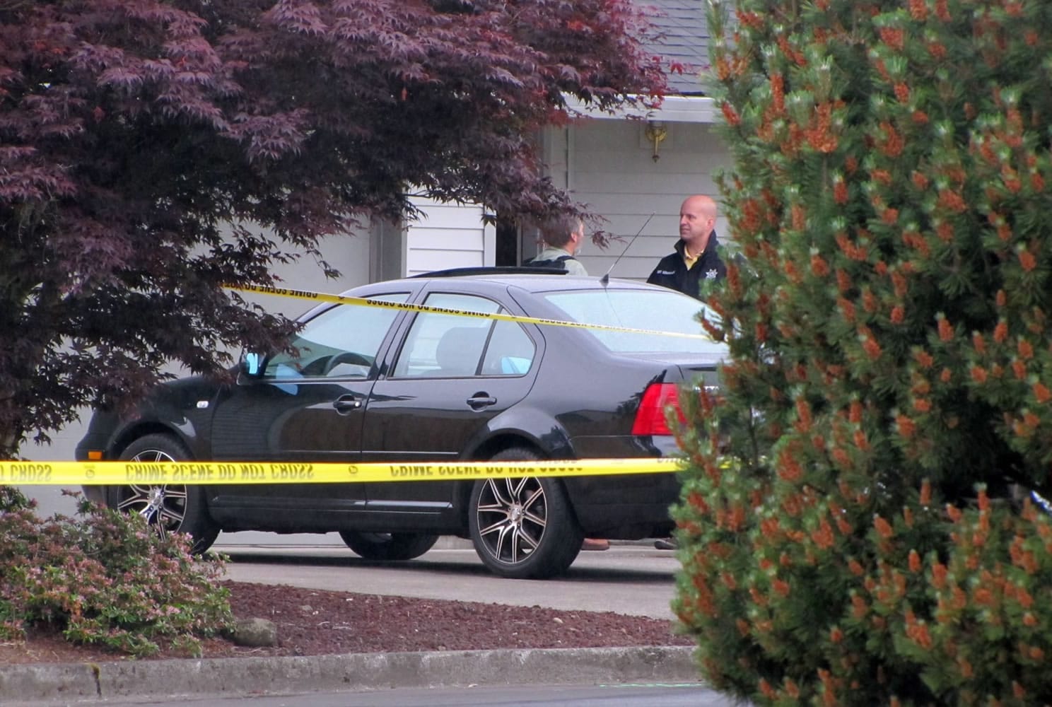 Sheriff's deputies talk in front of a home near the intersection of Northeast 101st Avenue and 72nd Circle in the Sunnyside neighborhood, north of Vancouver, after a shooting Tuesday morning.