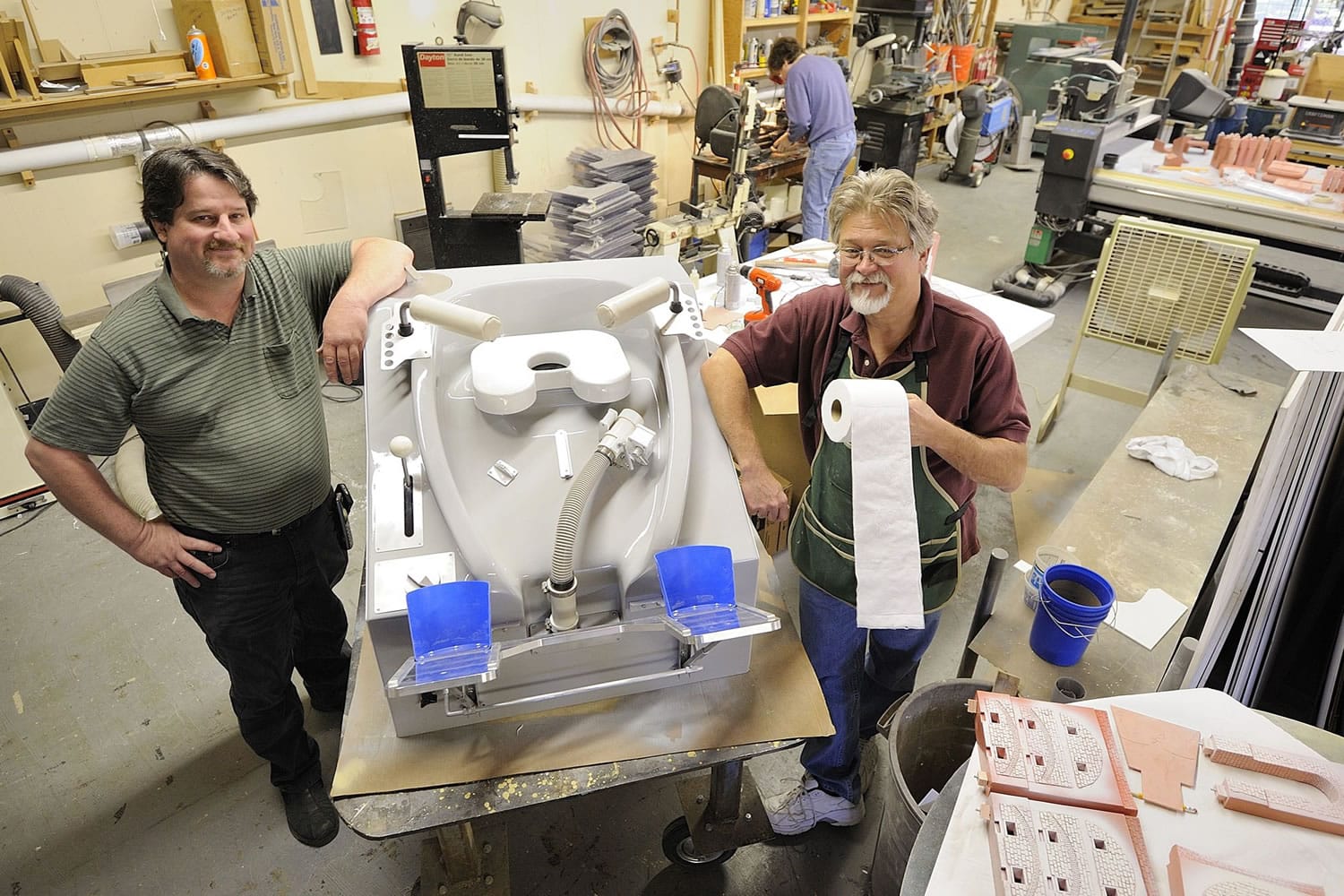 John Geigle, CEO of Masterpiece Models, and Ed Warmack, a fabricator at the company who helped build the space toilet, stand next to a full-size replica space shuttle toilet created for a museum in Kansas. The museum says the No.