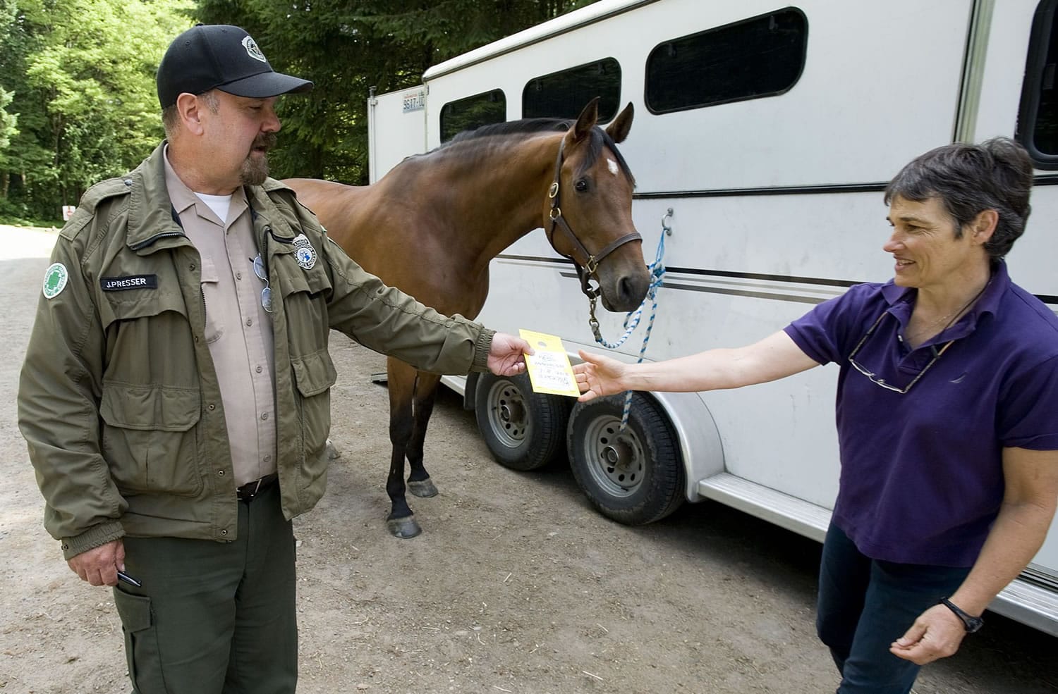 Battle Ground Lake State Park manager Jim Presser issues an annual Discover Pass to Ridgefield's Aimee Witherspoon, shown with her horse &quot;Worth the Wait.&quot; The Discover Pass, for day use, costs $30 and helps support the state park system.