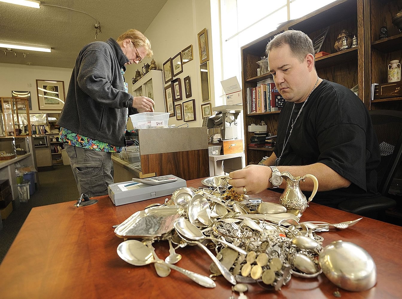 Pacific Jewelry owner Norbert Anderson, left, and Tim Murray, a buyer, sort through salvage metal.