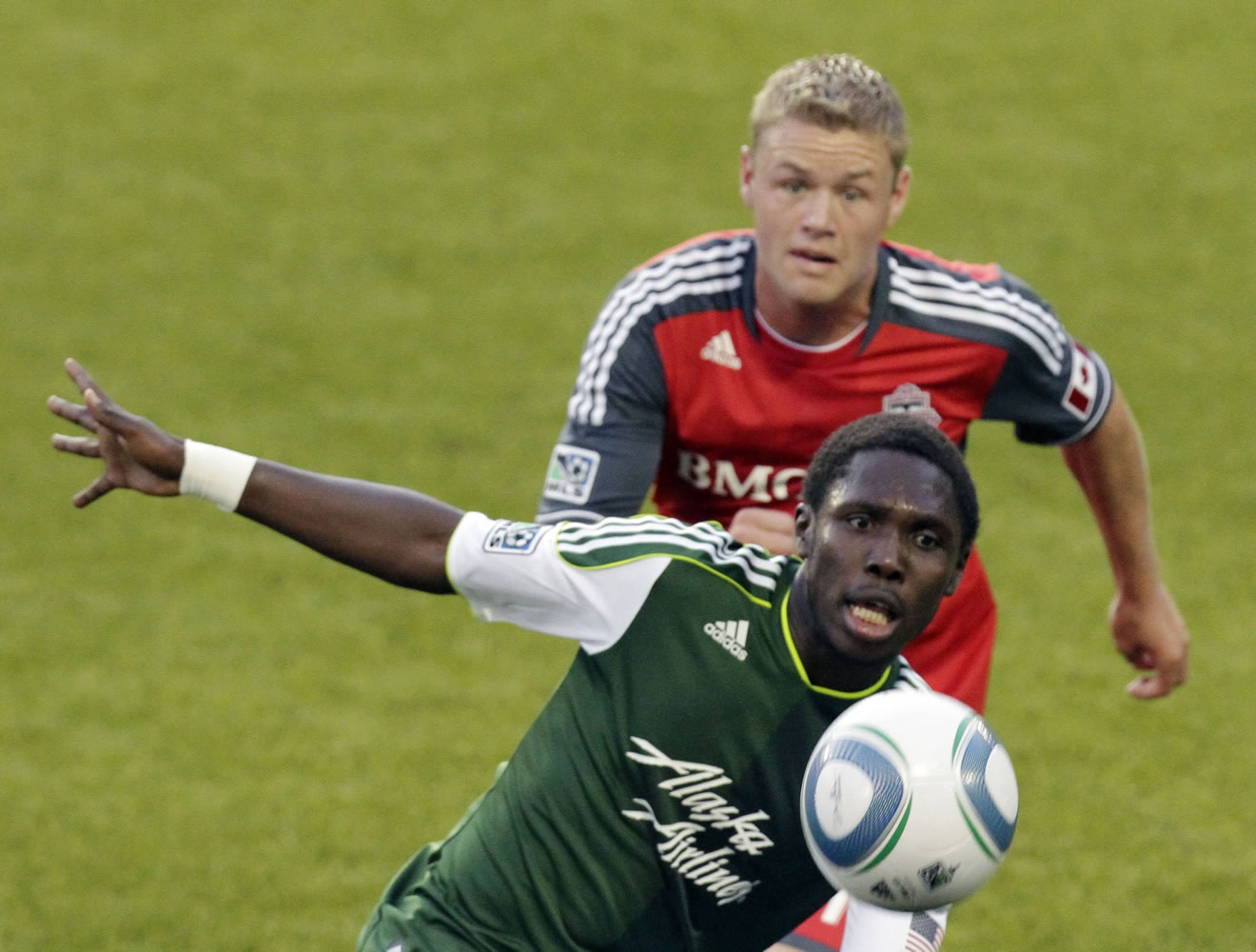 Portland Timbers midfielder Kalif Alhassan, front, chases the ball as Toronto FC's Nick Soolsma defends during the first half of Saturday's MLS match.