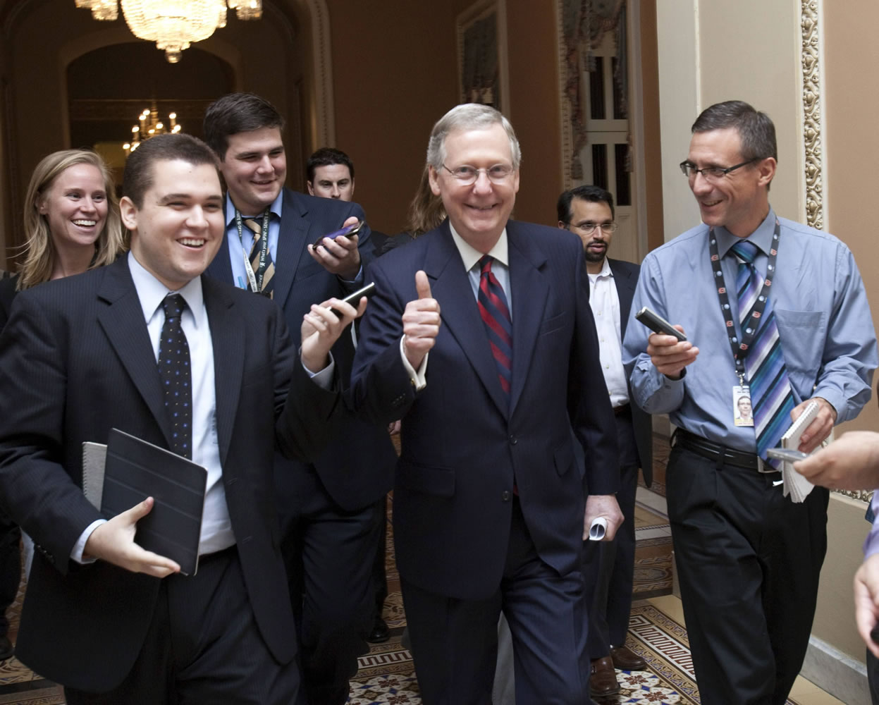 Senate Minority Leader Mitch McConnell, R-Ky., is all smiles Sunday as he walks to the Senate floor to announce that a deal has been reached on the debt ceiling on Capitol Hill in Washington.