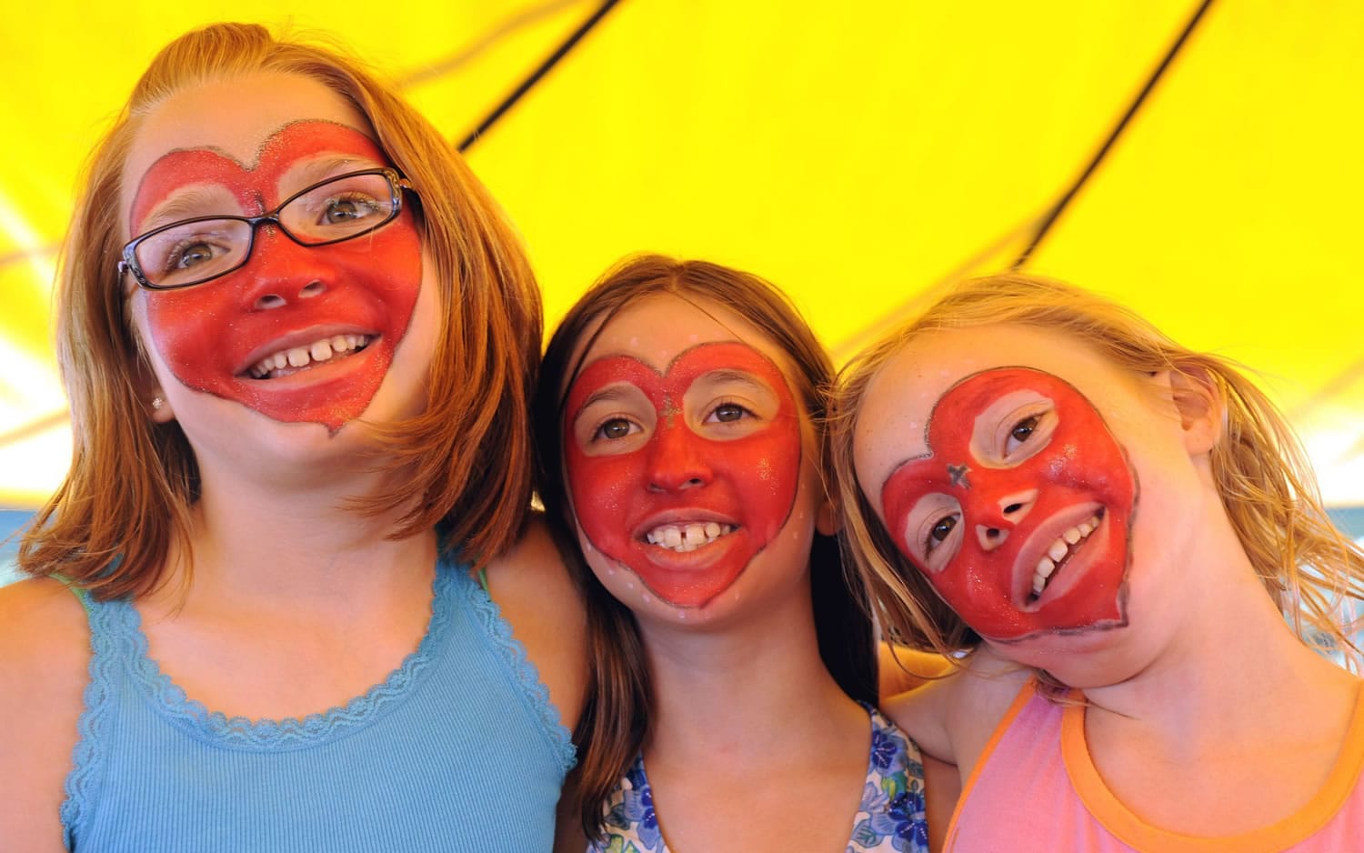 Emma Haynie, from left, Danielle Haner and Faith Hurley show off their face paintings at the picnic.