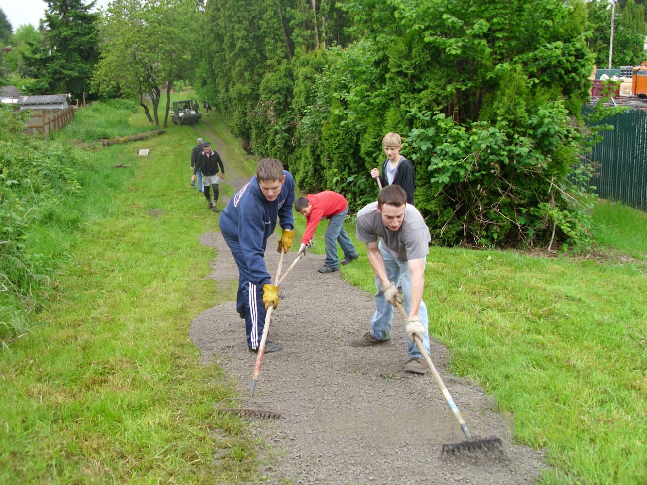 Members of Eagle Scout Troop 393, Josh Hauxhurst, from left, Andrew Park, David Zakand, Trevor Brown right front, spread gravel on the Ellen Davis Trail in late May.