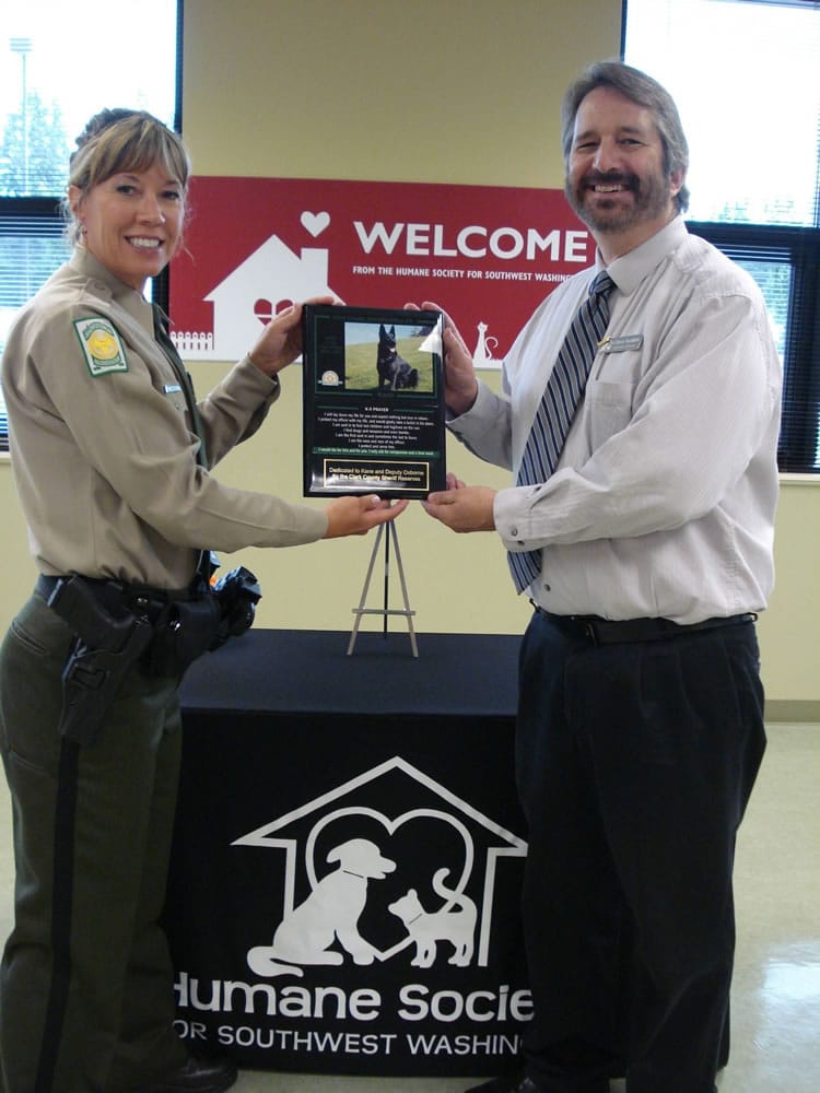 Clark County Sheriff Reserve Association President Debora Wonderly, left, presents a memorial plaque honoring the life of fallen K-9 officer Kane to Humane Society for Southwest Washington Executive Director Chuck Tourtillott earlier this year.