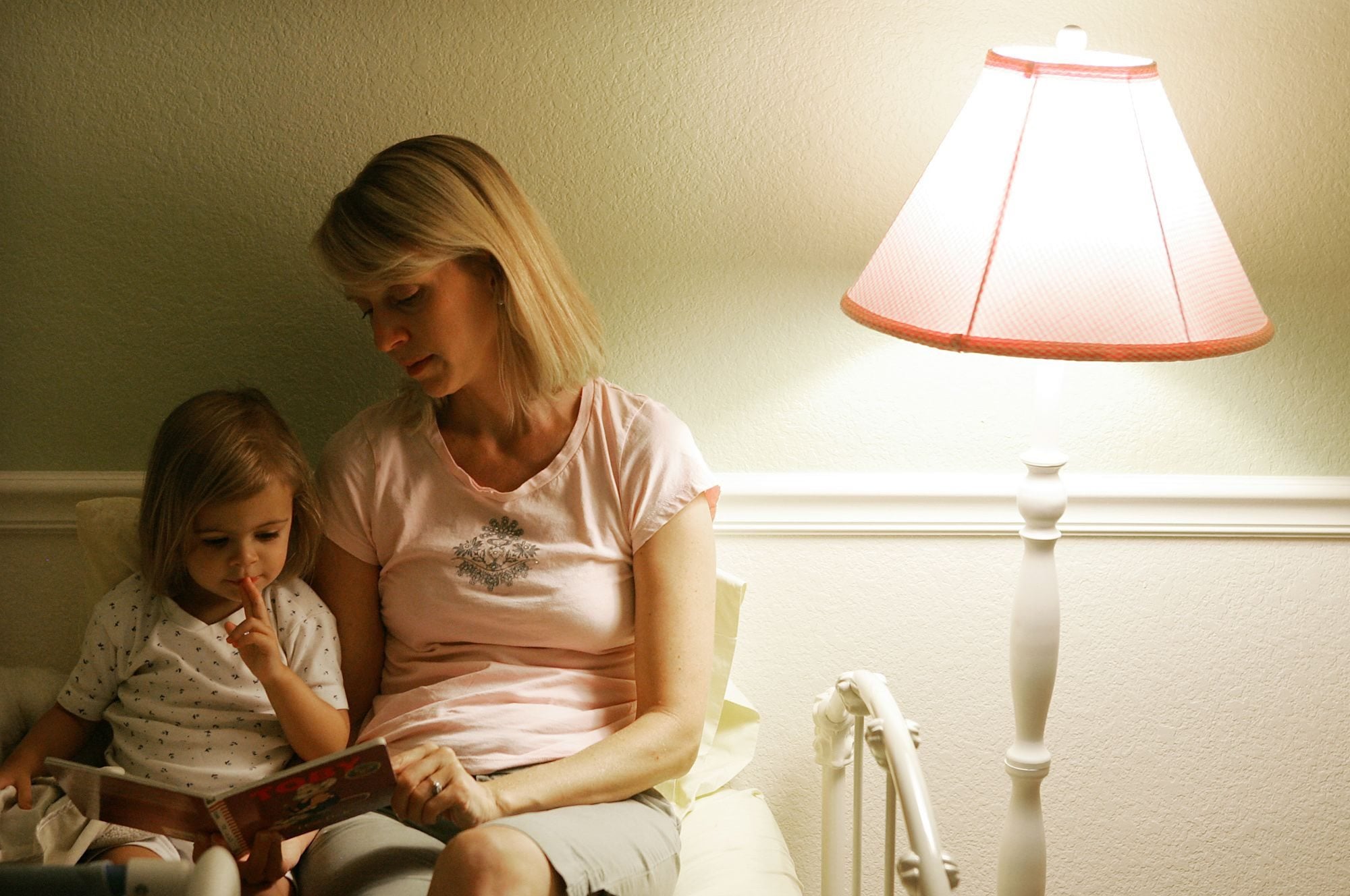 Allysa Adams, right, reads a bedtime story to her younger daughter, Andie Adams Urbinato, 2 1/2, at their home in Phoenix, Ariz. in this 2007 file photo.