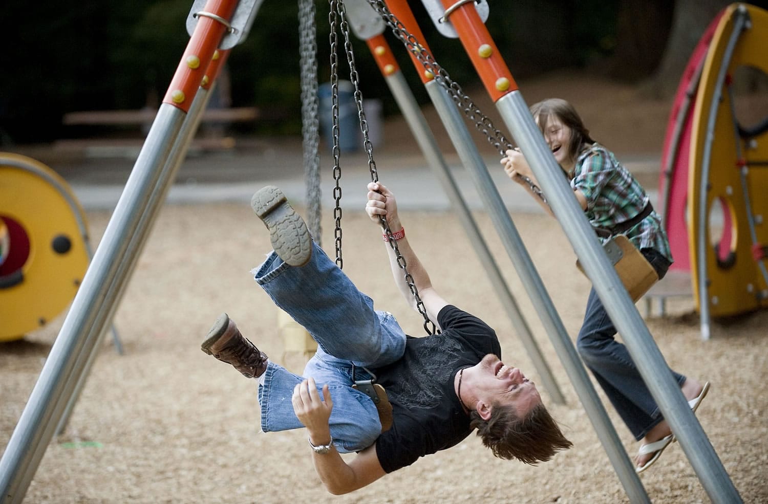 Sean Snyder and his daughter, Chloe Snyder, 9, play on the swings at Orchards Community Park in Orchards.