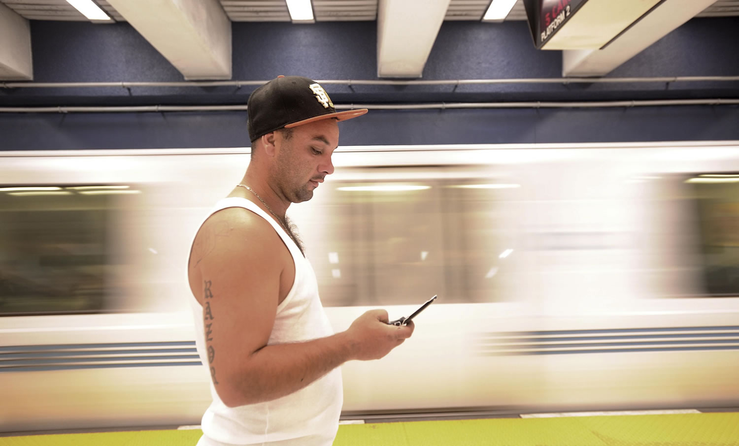 Drew Rojas checks his cell phone while waiting for a BART train at San Francisco's Civic Center station on Saturday.