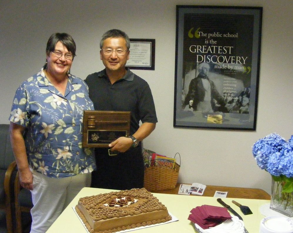 Robyn, left, and Sam Kim stand with the plaque presented to him for his 16 years on the Battle Ground school board.