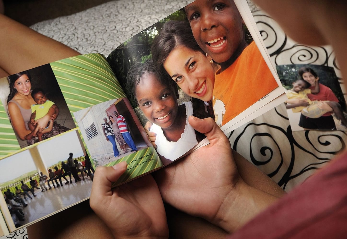 Haylee Castro looks at a photo book created by her sister, Lauren, following her Haiti relief trip this summer.