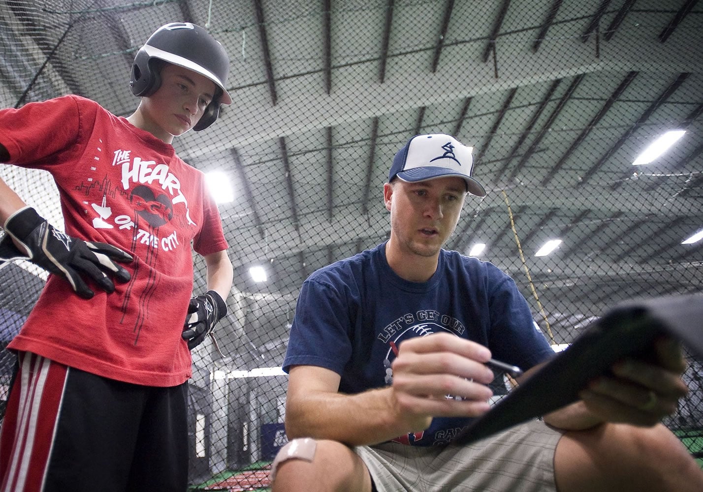 Chris Gissell, co-owner of Extra Innings in east Vancouver, evaluates a one-on-one hitting lesson with Max Hopkins, 14.