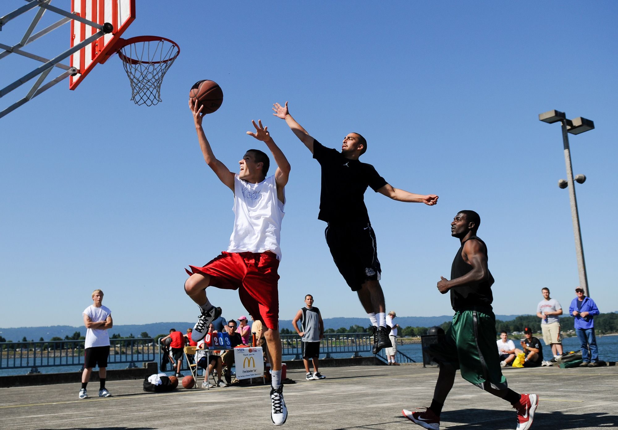 Jesse Kelsey of the Roos beats TBlaze's Joey Robleto for a layup during the Hoops on the River 3-on-3 basketball tournament Saturday. More than 200 teams signed up for the event that benefits Share.