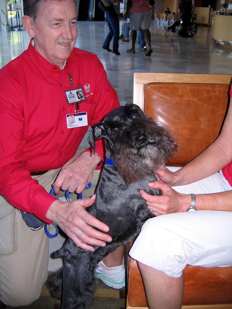 Peter Christensen and his miniature schnauzer, Mukaluka Dirtypaws, visit the waiting room at Legacy Salmon Creek Medical Center as part of the Delta Society Pet Partners program.