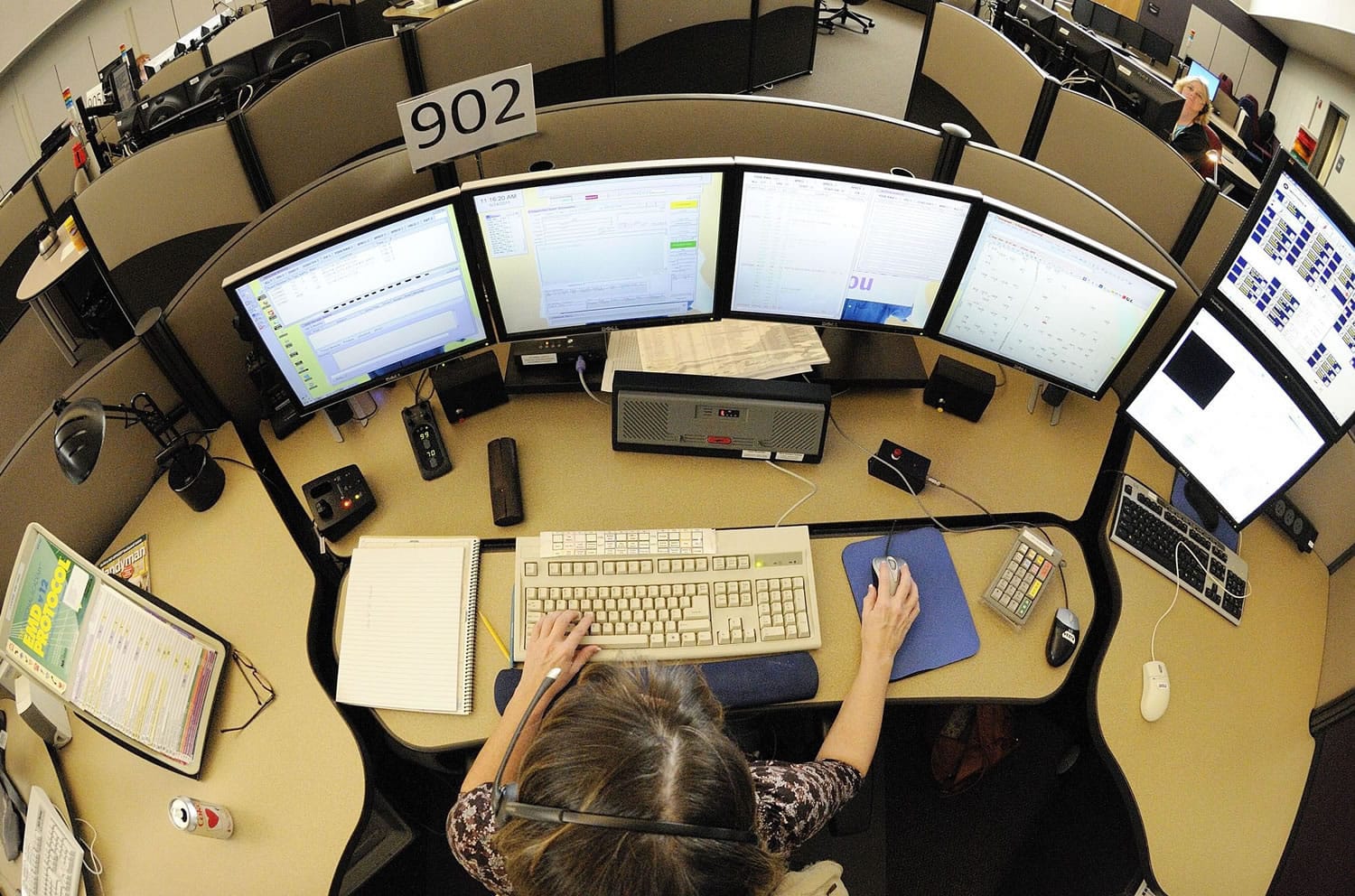 A 911 dispatcher works several computer screens, keeping track of officers with the Clark County Sheriff's Office and six other police departments.